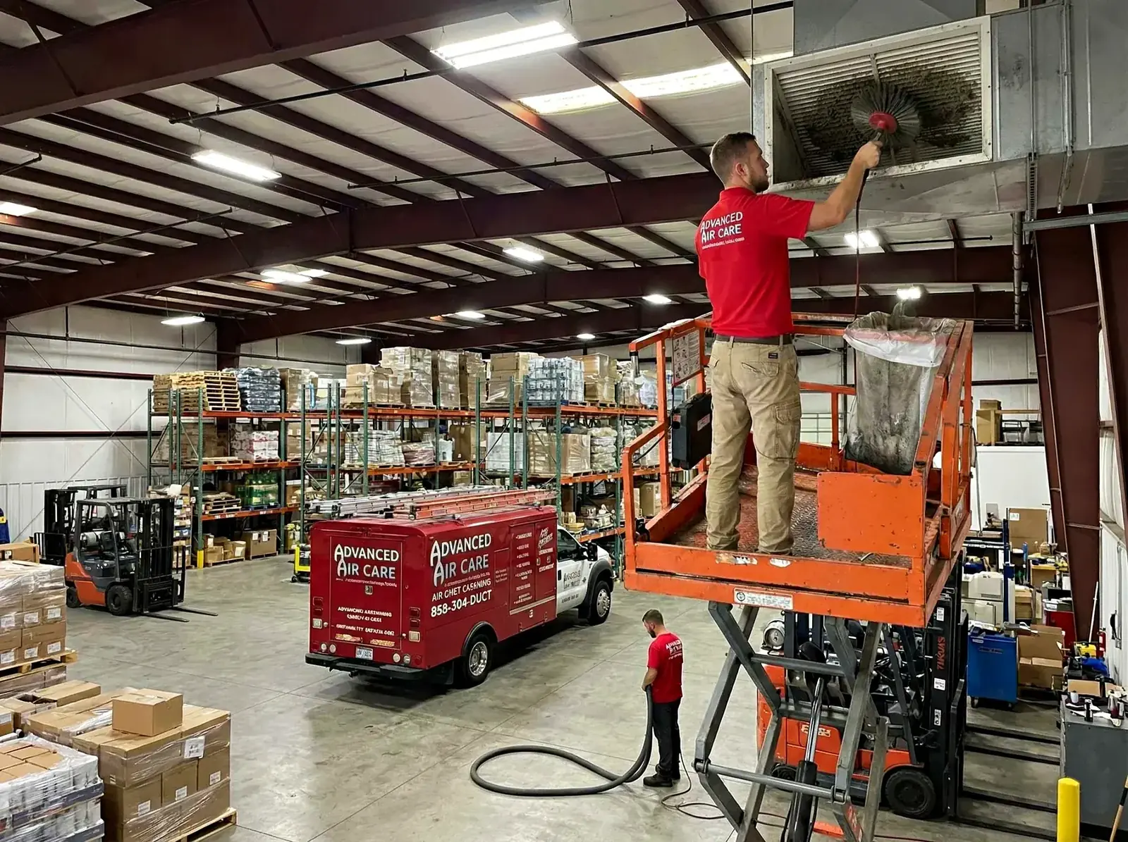 Technicians cleaning high ductwork in a Metro Detroit warehouse