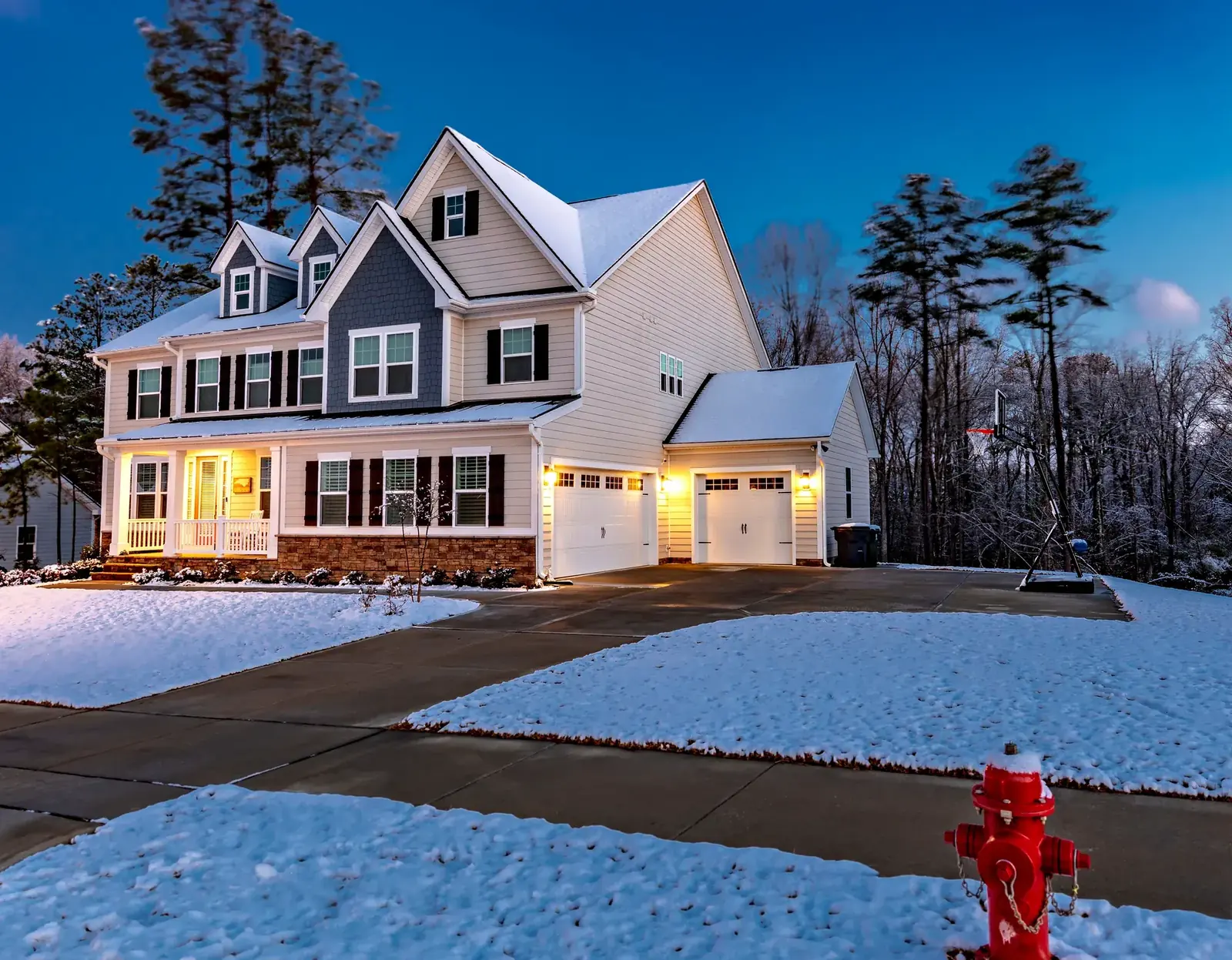 Suburban Michigan home in the snow at twilight with the furnace running
